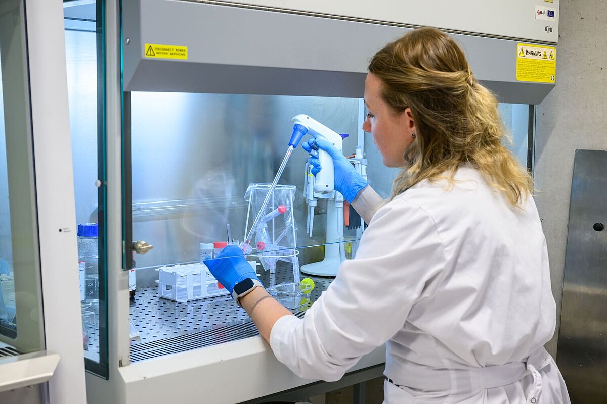 Laborante laboratorijā ar pipeti veic parauga izpēti.