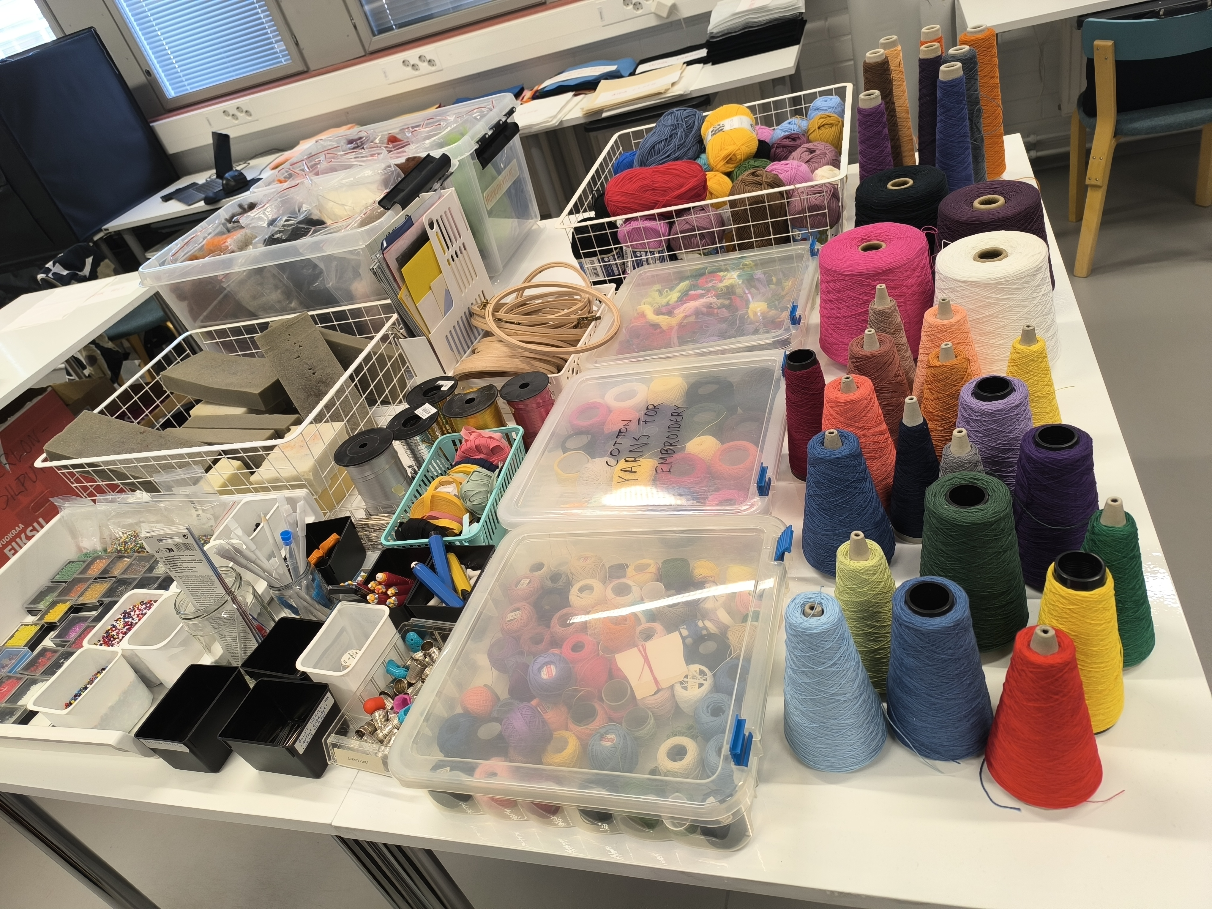 Dažādi krāsaini šūšanas rokdarbu materiāli uz galda